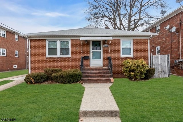 bungalow-style house with entry steps, brick siding, and a front yard