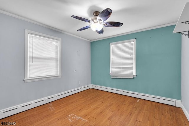 unfurnished room featuring ceiling fan, baseboard heating, crown molding, and wood finished floors