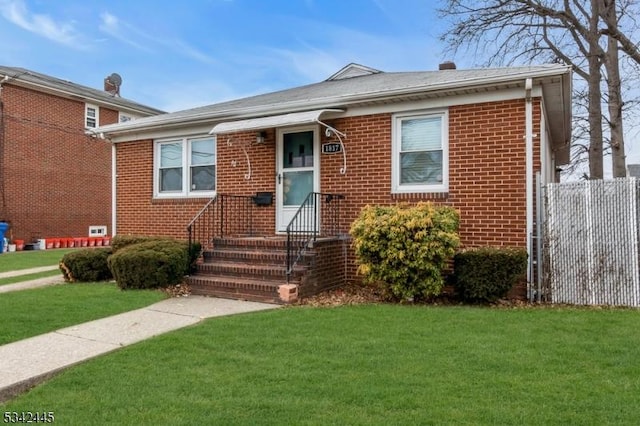 bungalow featuring a front yard, brick siding, and fence