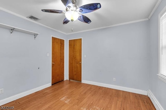 unfurnished bedroom with baseboards, visible vents, ornamental molding, wood finished floors, and baseboard heating