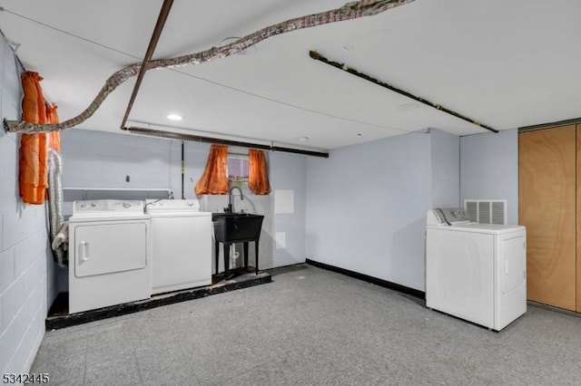 laundry area with laundry area, visible vents, washer and dryer, light floors, and a sink