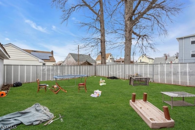 view of yard featuring a trampoline and a fenced backyard