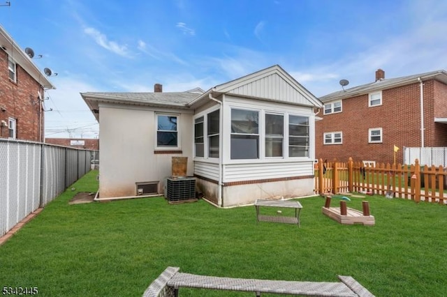 back of property with a lawn and a fenced backyard