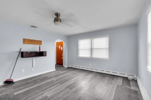 unfurnished living room featuring visible vents, arched walkways, a baseboard radiator, ceiling fan, and wood finished floors