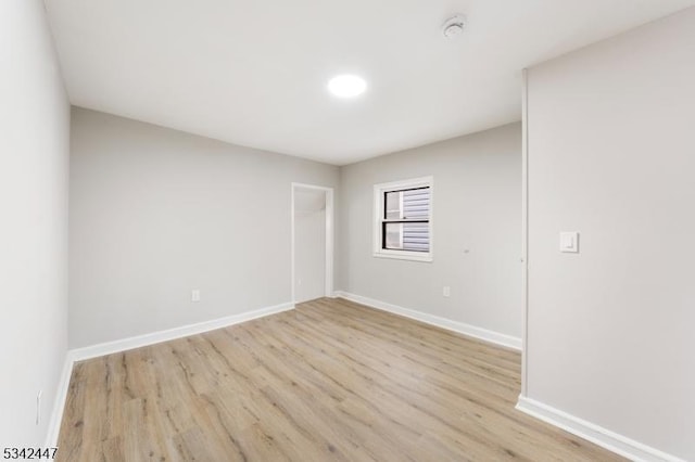 unfurnished room featuring baseboards and wood finished floors