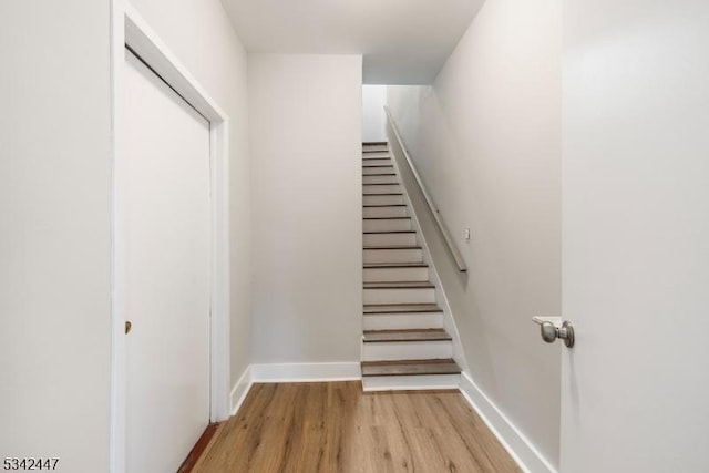 staircase with baseboards and wood finished floors