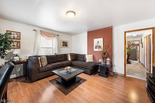 living room featuring baseboards, baseboard heating, and light wood-style floors