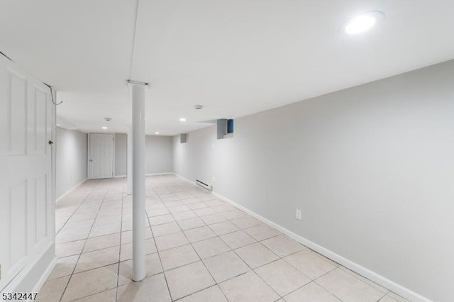 finished below grade area with recessed lighting, light tile patterned flooring, a baseboard radiator, and baseboards