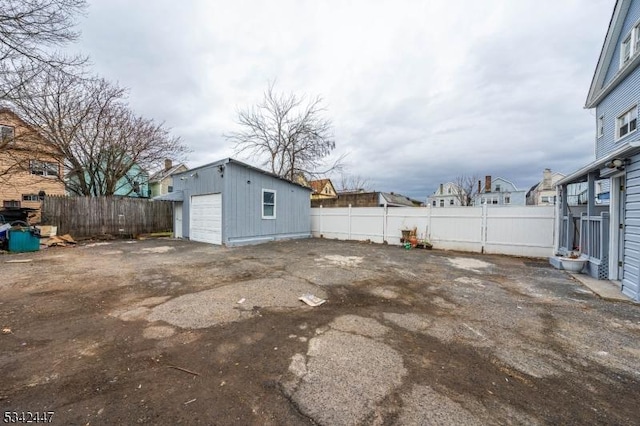 view of yard featuring an outbuilding, fence, and a detached garage