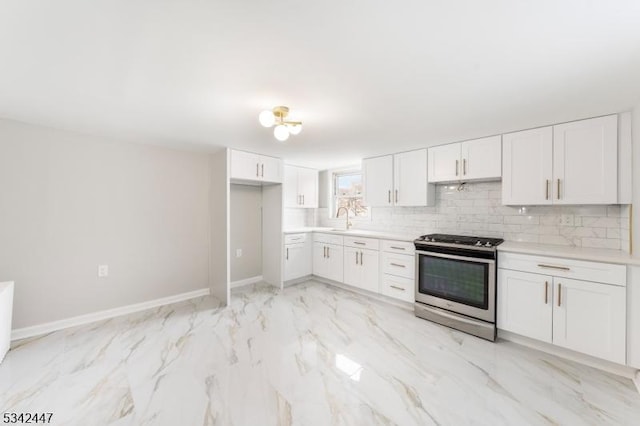 kitchen featuring stainless steel stove, a sink, white cabinets, light countertops, and backsplash