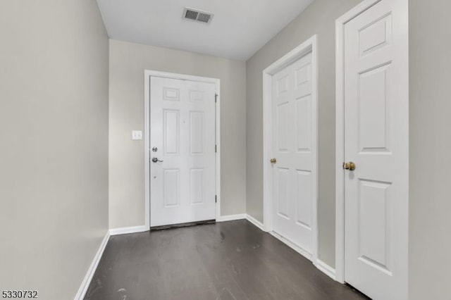 foyer with visible vents, dark wood finished floors, and baseboards