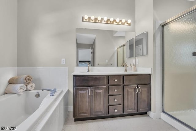 bathroom with a stall shower, a garden tub, a sink, and double vanity