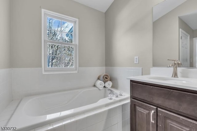 full bathroom featuring a garden tub and vanity