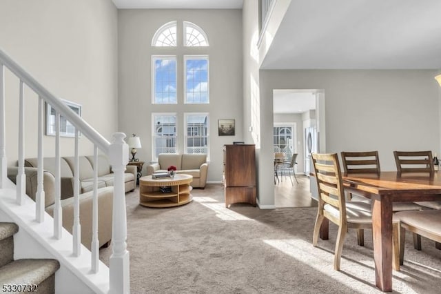 interior space featuring stairway, a towering ceiling, and baseboards