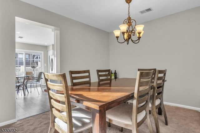 carpeted dining room featuring baseboards, visible vents, and a chandelier