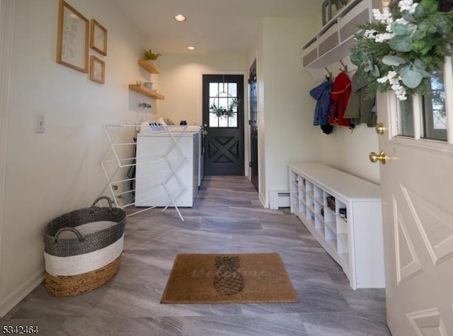 mudroom featuring a baseboard heating unit, recessed lighting, baseboards, and washing machine and clothes dryer