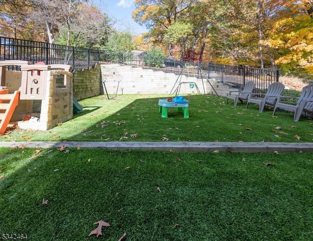 view of play area with fence and a lawn