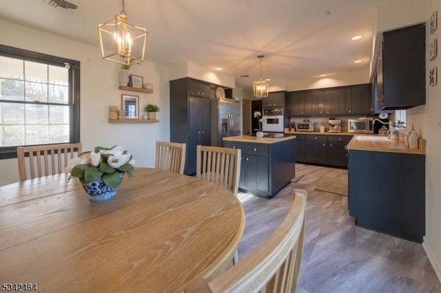 dining room featuring visible vents, a toaster, recessed lighting, light wood-style floors, and an inviting chandelier