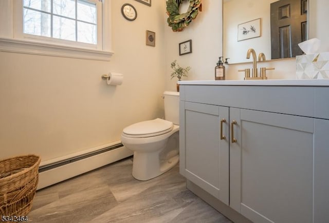 bathroom with toilet, vanity, and a baseboard radiator