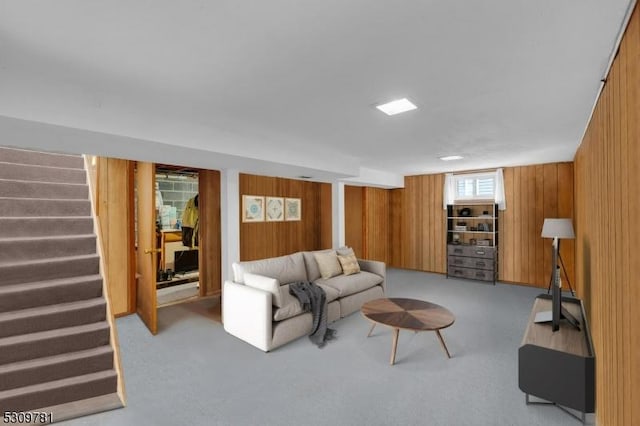 living area with stairway, carpet floors, and wooden walls