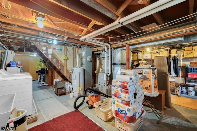 unfinished basement featuring water heater and washing machine and clothes dryer