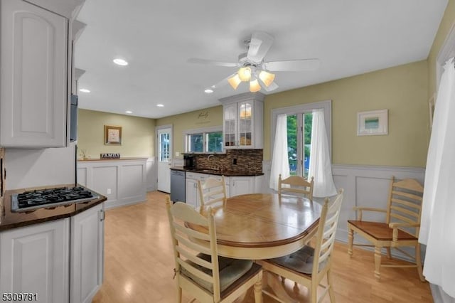 dining space with recessed lighting, a wainscoted wall, light wood-style floors, and ceiling fan