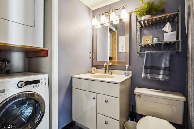 half bath featuring washer / dryer, vanity, and toilet