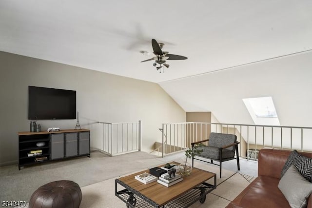 living area featuring carpet floors, lofted ceiling with skylight, and a ceiling fan