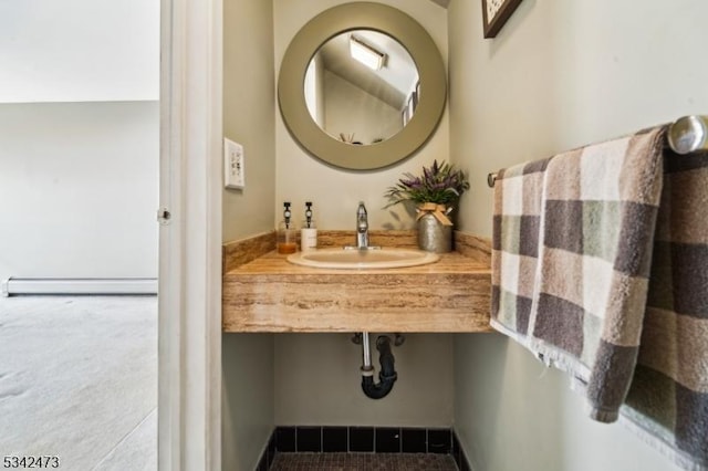 bathroom featuring a baseboard heating unit and a sink