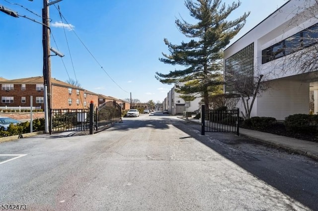 view of street with a residential view, a gate, and sidewalks