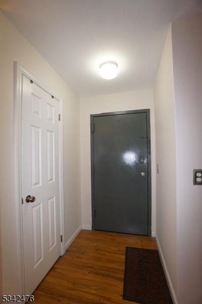 doorway to outside with wood finished floors and baseboards