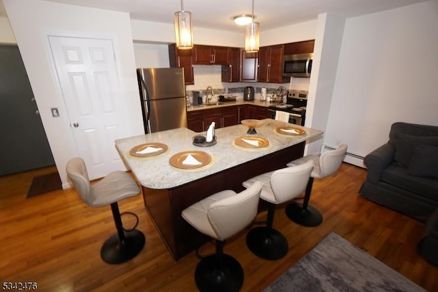 dining area featuring a baseboard radiator and wood finished floors