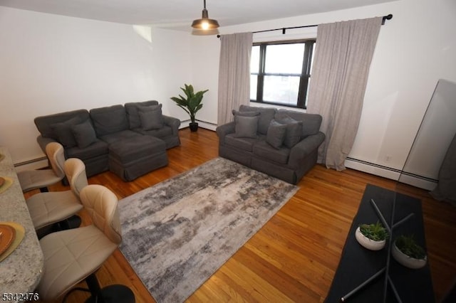 living area featuring a baseboard heating unit and wood finished floors