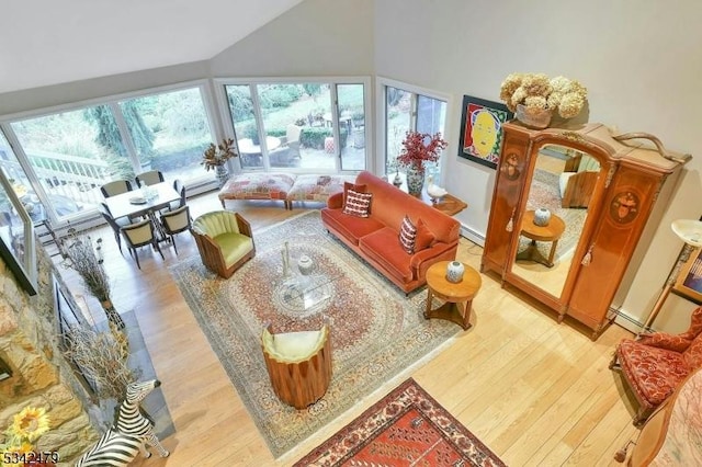 living room with lofted ceiling, light wood finished floors, and a healthy amount of sunlight