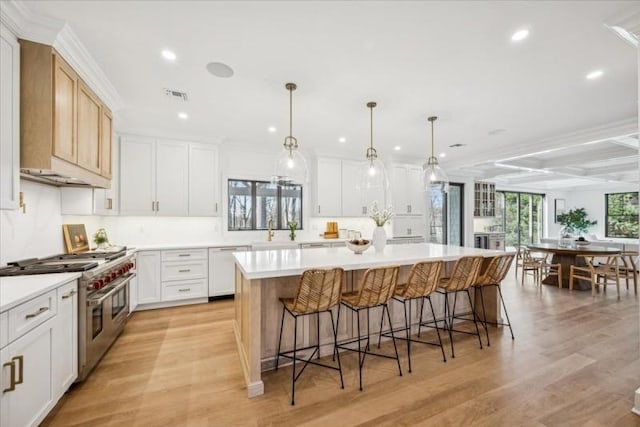 kitchen with visible vents, range with two ovens, dishwasher, a breakfast bar, and a center island