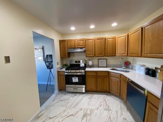 kitchen featuring brown cabinets, stainless steel range with gas stovetop, a sink, dishwasher, and under cabinet range hood