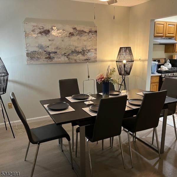 dining space featuring light wood finished floors and baseboards