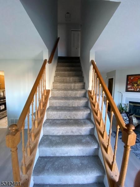 stairs with a glass covered fireplace