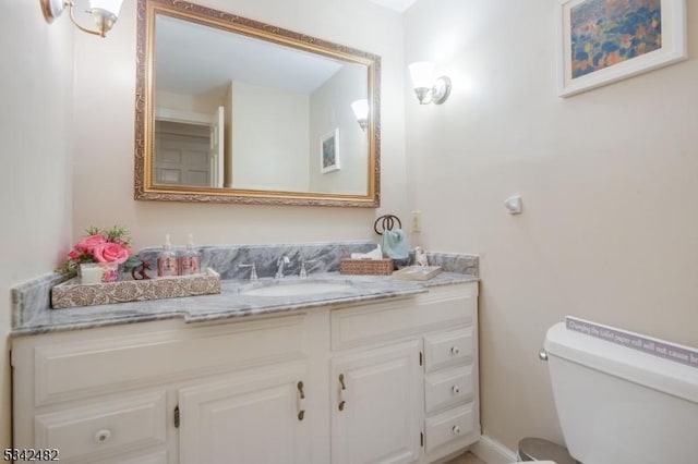 half bathroom with toilet and vanity