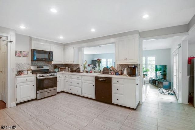 kitchen featuring black appliances, white cabinetry, decorative backsplash, and light countertops