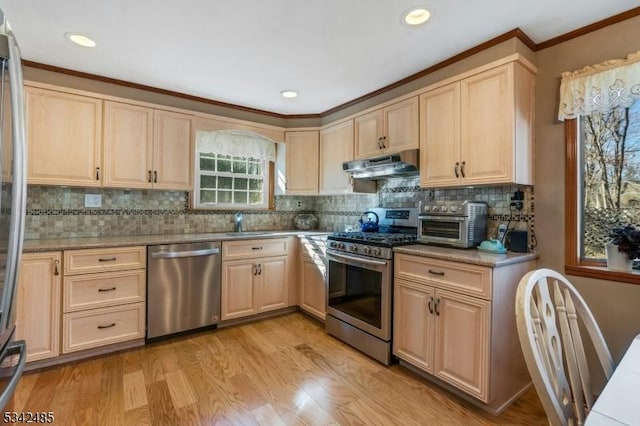 kitchen with stainless steel appliances, light wood-style floors, under cabinet range hood, and light brown cabinetry