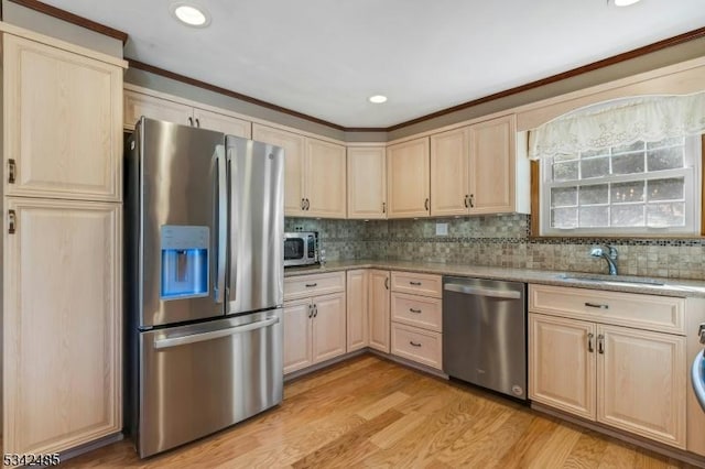 kitchen featuring light brown cabinets, appliances with stainless steel finishes, and a sink