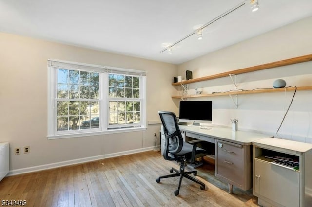 office featuring light wood-style floors, baseboards, and rail lighting