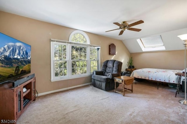 bedroom with lofted ceiling with skylight, carpet flooring, baseboards, and a ceiling fan