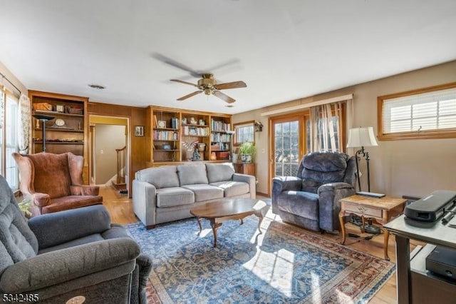 living area featuring light wood-style flooring and a ceiling fan