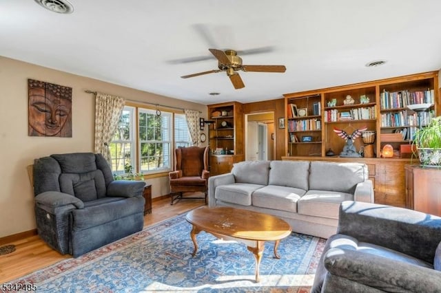 living area featuring visible vents, light wood-style flooring, and baseboards