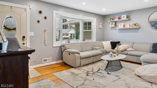 living room with baseboards, visible vents, wood finished floors, and recessed lighting