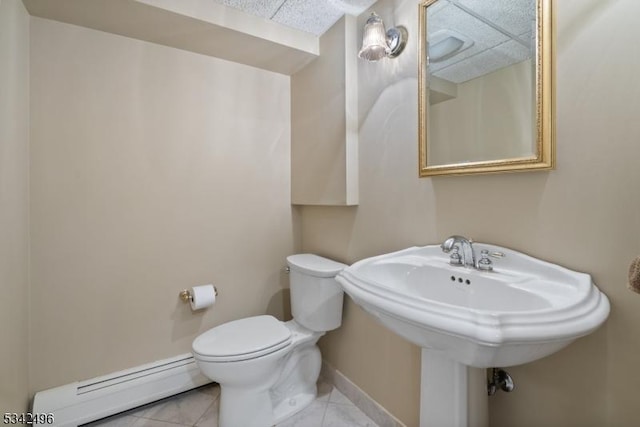 bathroom with tile patterned flooring, baseboards, toilet, and baseboard heating