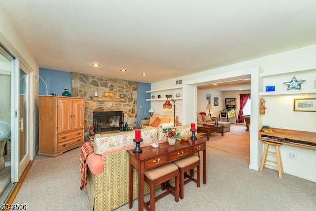 living room featuring recessed lighting, a fireplace, visible vents, and light colored carpet