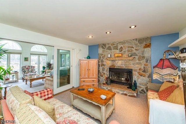 carpeted living room with a stone fireplace